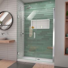 a bathroom with a glass shower door next to a sink and wooden counter top under a round mirror