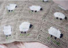 a crocheted blanket with black and white sheep on it