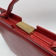 a red purse with a gold clasp on it