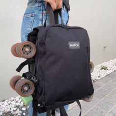 a person holding a skateboard with wheels attached to it's back pocket,