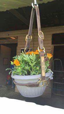 a hanging planter with flowers in it and a name tag attached to the bottom