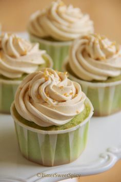 cupcakes with white frosting and sprinkles on a plate