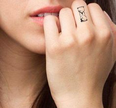 a close up of a person with a ring on her finger and an anchor tattoo