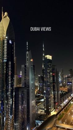 an aerial view of the city at night with lights and skyscrapers in the foreground