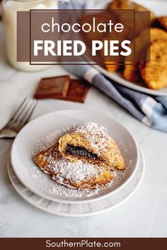 chocolate fried pies on a plate with powdered sugar and milk in the background