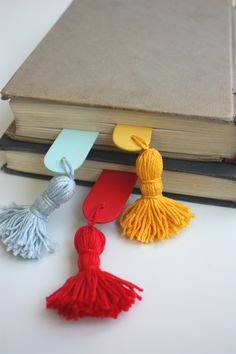 three tassels are placed next to an open book