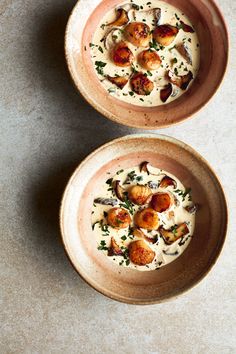 two bowls filled with food on top of a table