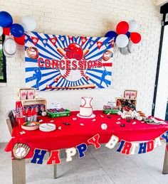 a baseball themed birthday party with red, white and blue decorations on a table in front of a sign that says congratulations