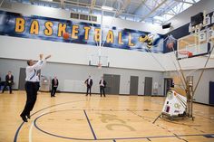 a group of men playing basketball inside of a gym with an advertisement on the wall