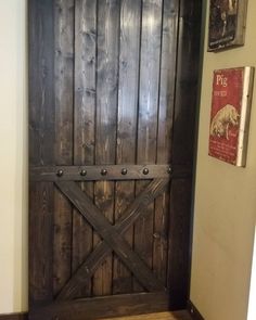 an old wooden door with metal bars on the front and side, in a hallway