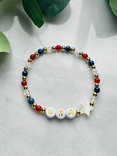 Show your patriotism with this festive USA bracelet. Perfect for Fourth of July, Memorial Day or any patriot loving event. Made with natural gemstones and 18k gold filled beads that are much more tarnish resistant and lasting opposed to the the more commonly seen gold plated. You will have this forever!  These bracelets layer well with others so add this to your stack! Sizing for girls and women. Beaded on high quality stretch cord and secured. - Choice of USA bracelet or set -  4mm 18k gold filled beads      4mm lapis stone (blue)    4mm quartz    4mm carnelian stone (red)    acrylic letters beads    mother of pearl stars     - If you would prefer different personalization other then "USA", please enter in personalization box - Each purchase is sent in a drawstring velvet jewelry bag, mak Red Bracelets For 4th Of July Gift, Patriotic Beaded Bracelets For Independence Day, Patriotic Round Beads Jewelry Gift, Patriotic Bracelets For 4th Of July Gift, Red Jewelry For Friendship On 4th Of July, Patriotic Round Beads Stretch Bracelet For 4th Of July, White Bracelets For 4th Of July Gift, Patriotic Beaded Bracelets For 4th Of July, Patriotic Beaded Bracelets For Gifts