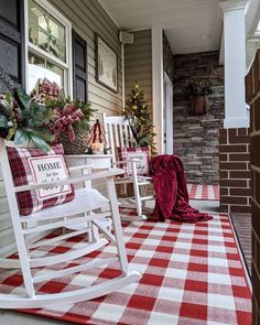 two rocking chairs on the front porch decorated for christmas with red and white checkered rug