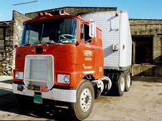 an orange and white truck parked in front of a building