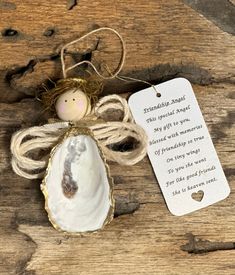 an angel ornament on a wooden table with a tag that says, thank you