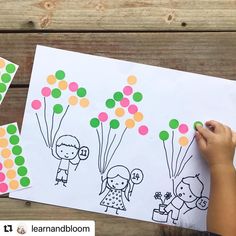 a child's hand drawing on paper with balloons