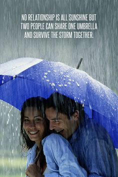 two people hugging under an umbrella in the rain