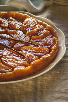 a close up of a pie on a plate with some sticks in it's center