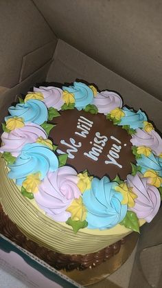 a birthday cake with frosting and flowers in a box