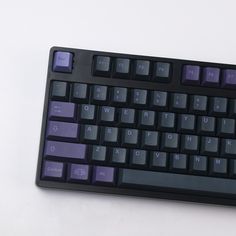 a black and purple keyboard on a white surface