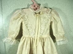 "We are pleased to offer for sale this ecru colored eyelet, embroidered cotton doll dress that we would date to be from the 1970's. The dress has a fitted waist, long puff sleeves that are trimmed with scalloped white lace. The high collar is also trimmed with that same lace and accented with two pale yellow silk flowers and a lace ribbon bow. There is that same lace trim that comes down in a \"V\" on the bodice. The full skirt is embroidered at the bottom with a flower design and has a scallope Spring Costume Vintage Dress With Long Sleeves, Spring Long Sleeve Vintage Dress Costume, Spring Vintage Long Sleeve Dress For Costume, Spring Vintage Long Sleeve Costume Dress, Fitted Vintage Victorian Dress With Doll Collar, Fitted Victorian Dress With Doll Collar, Fitted Cream Dress With Broderie Anglaise, White Vintage Dress With Doll Collar, Spring Victorian Long Sleeve Costume Dress