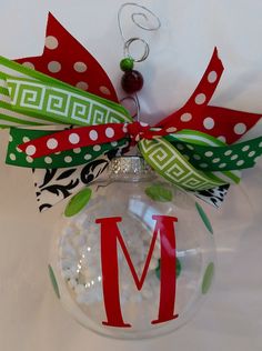 a christmas ornament with a monogrammed letter on it and a bow