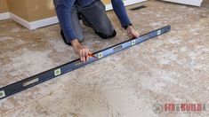 a man is measuring the floor with tape