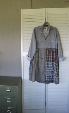 an old shirt hanging on a door next to a filing cabinet