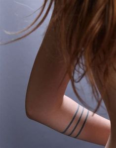 a woman with tattoos on her arm holding a cell phone