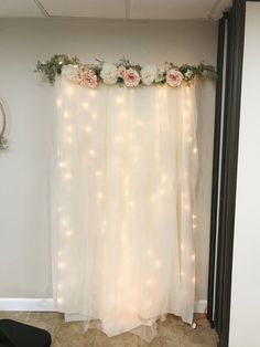 a white curtain decorated with flowers and lights