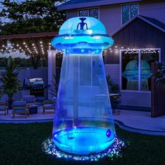 an illuminated water fountain in front of a house