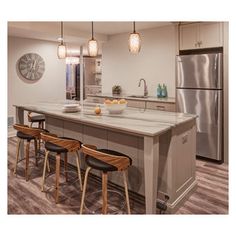 a kitchen island with stools in front of it and a clock on the wall