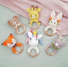 six crocheted animal teeth and rings on a blanket