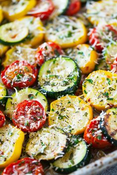 a pan filled with sliced up zucchini, tomatoes and other veggies