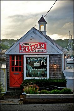 the ice cream store has red doors and a clock tower on it's roof