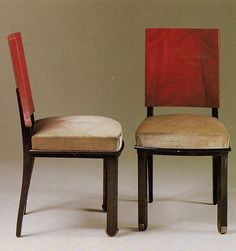 two chairs sitting next to each other in front of a wall