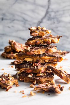 a stack of cookies with nuts and chocolate on top