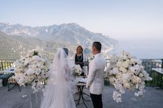 the bride and groom are getting ready to exchange their vows on top of the mountain