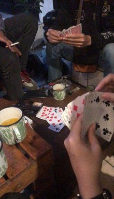 people sitting around playing cards and drinking tea