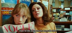 two women sitting next to each other in front of books