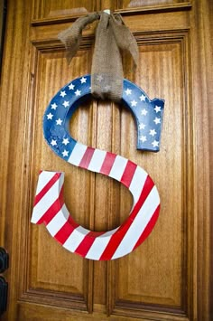 a door hanger with the letter c painted red, white and blue