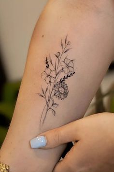 a woman's arm with flowers and leaves tattoo on the left side of her body