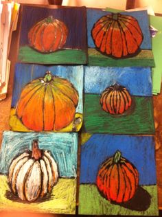 four paintings of pumpkins are displayed on a table