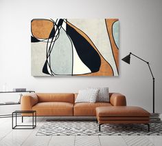 a modern living room with an orange couch and large painting on the wall above it