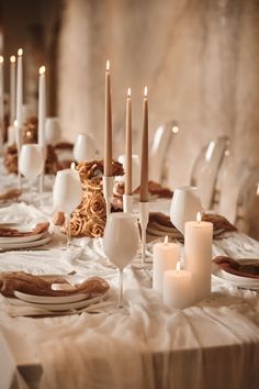 the table is set with candles and plates