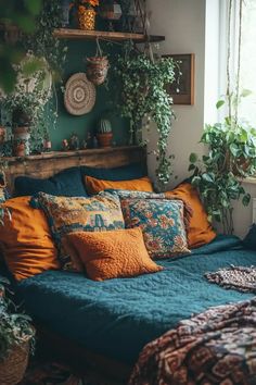 a bed with lots of pillows and plants on top of it in a room filled with potted plants