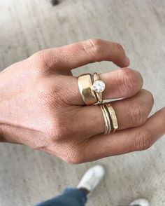 a person's hand with two gold rings on it and a diamond in the middle