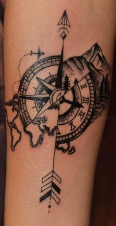 a black and white photo of a compass tattoo on the side of a woman's leg