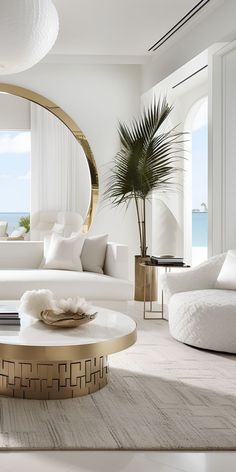 a living room filled with white furniture and a large mirror on the wall above it