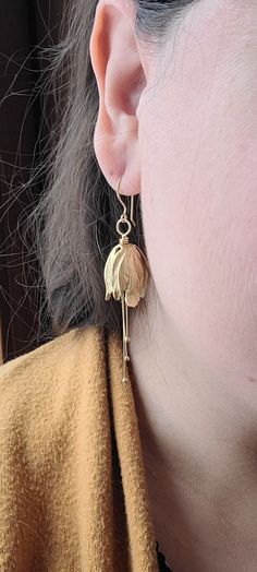 I thought to add a different flower to my store bouquet. Wondering in my favorite bead store, I found these unique gold plated brass tulip flower tops. Boy, was I in love! The free movement of the pollen dangles add an elegant touch. The hooks are hand hammered 14K gold plated over brass. I wear a pair when I go out on a date, to a wedding or even the opera.  Bridesmaids would be delighted to get a pair as a gift. They look great with any color and especially floral patterns. Gold Petal Flower Earrings For Gifts, Gold Petal Earrings For Gift, Delicate Gold Petal Flower Earrings, Gold Teardrop Flower Charm Earrings, Gold Teardrop Flower Earrings With Charm, Gold Teardrop Flower Earrings With Ear Wire, Delicate Gold Teardrop Flower Earrings, Delicate Gold Birth Flower Earrings, Yellow Gold Birth Flower Earrings