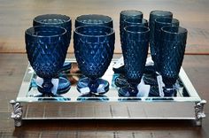 six blue glasses are sitting on a silver tray